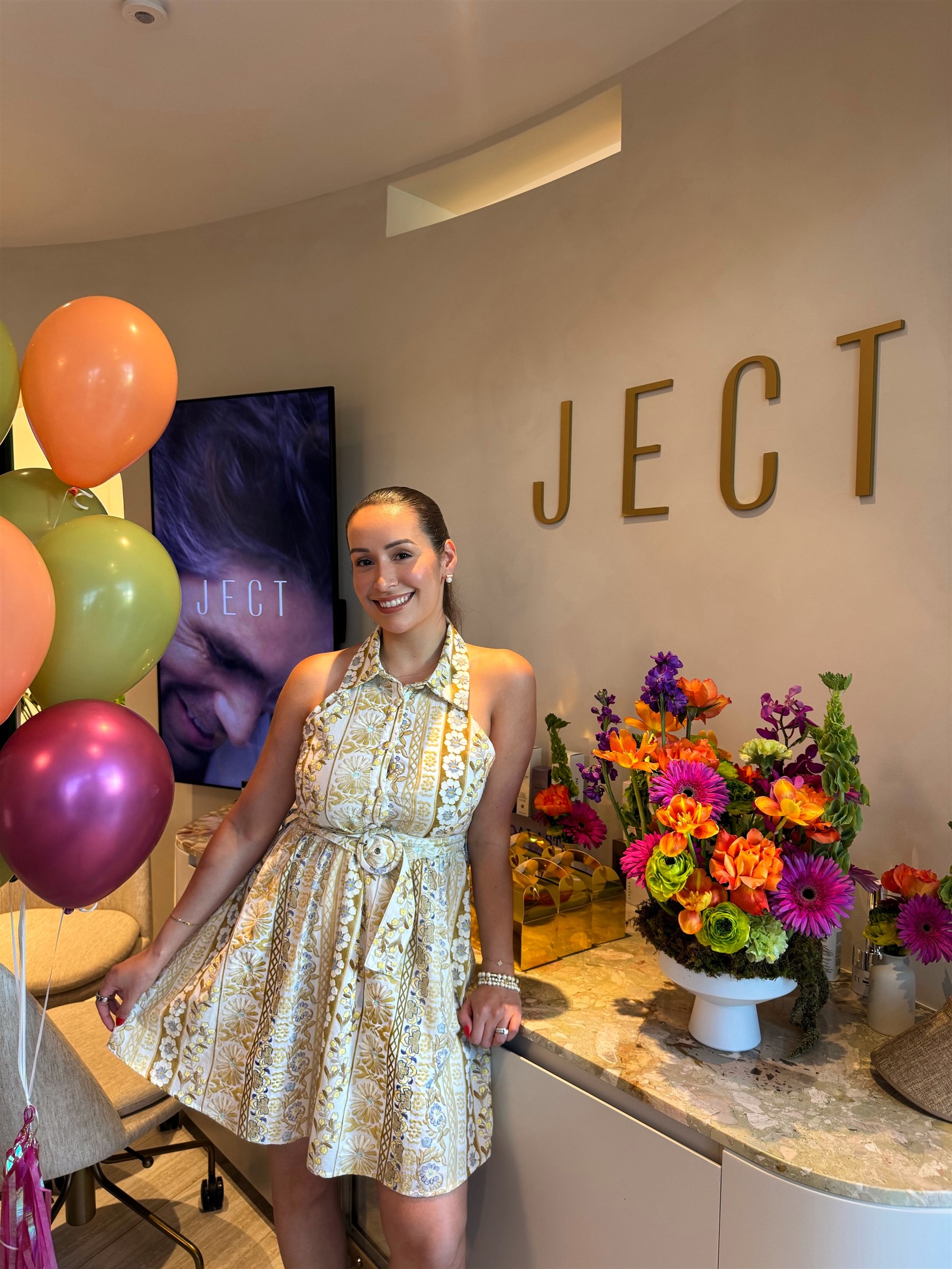 Nadia smiling beside the JECT sign in the Miami Beach studio