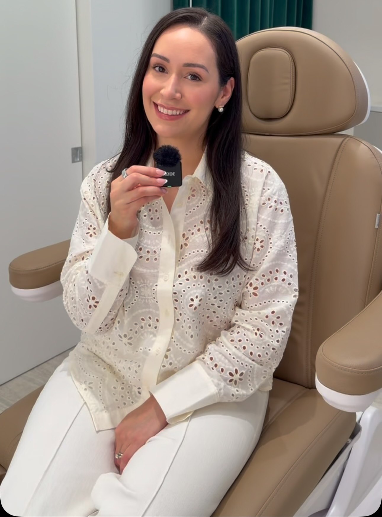Nadia Alvear, FNP-C, seated in a tan treatment chair in a white eyelet blouse